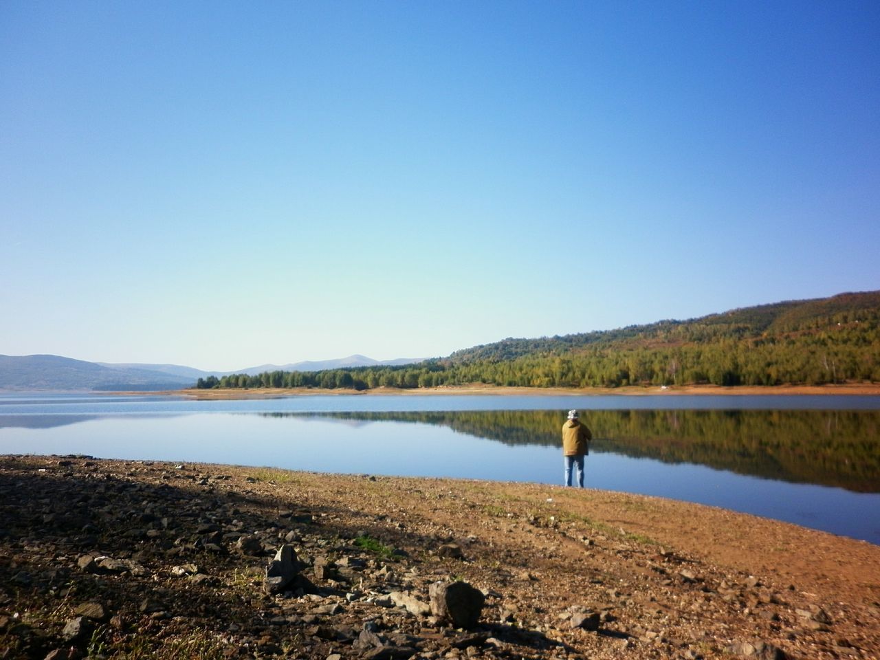 clear sky, water, copy space, lake, blue, tranquility, tranquil scene, scenics, beauty in nature, nature, reflection, mountain, tree, river, lakeshore, men, leisure activity, standing