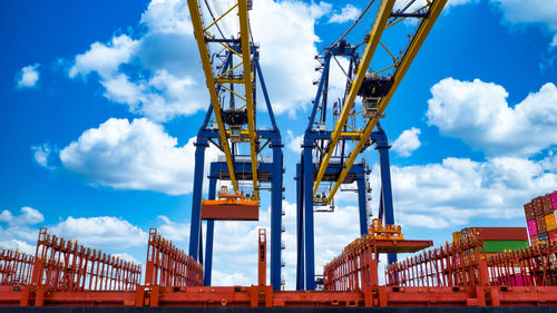 Low angle view of cranes against sky