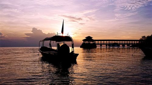 Boats in river at sunset