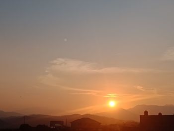 Silhouette buildings against sky during sunset