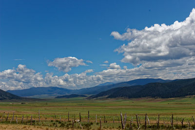 Scenic view of field against cloudy sky