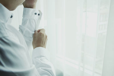 Midsection of businessman wearing shirt while standing at home