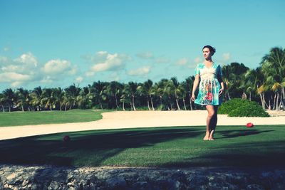 Full length of woman standing on field against sky