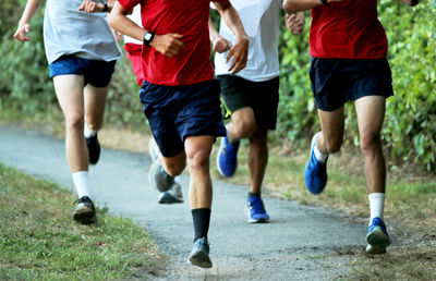 Low section of people running on soccer field