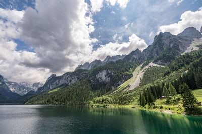 Scenic view of lake by mountains against sky