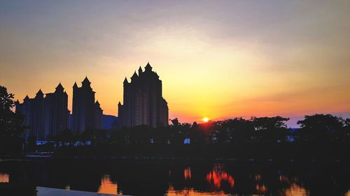 Silhouette of buildings against sky at sunset