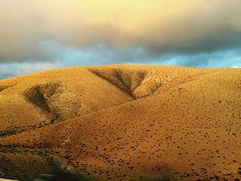 Sand dunes in desert against sky