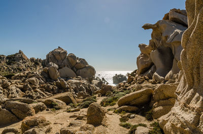 Panoramic view of rocks on beach against clear sky