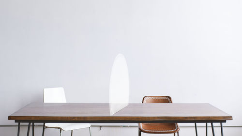Empty chairs and table against white background