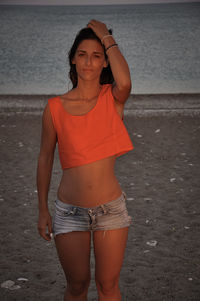 Portrait of beautiful young woman standing on beach