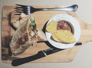 Directly above shot of barbecue chicken burrito served on wooden tray