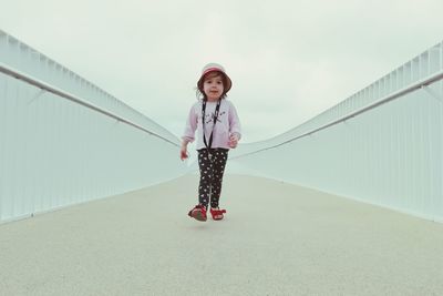 Full length portrait of girl walking on footbridge