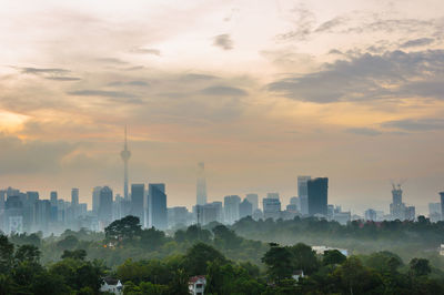 View of buildings in city against cloudy sky