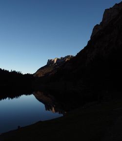 Scenic view of lake and mountains against clear sky