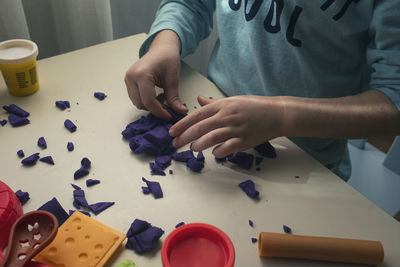 High angle view of child holding hands on table