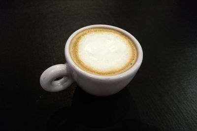 High angle view of cappuccino on table against black background