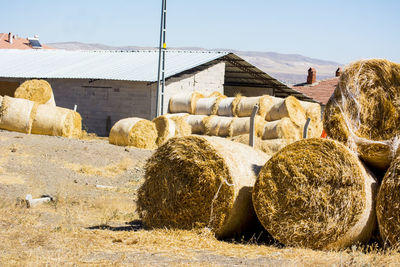 Hay bales on field against sky