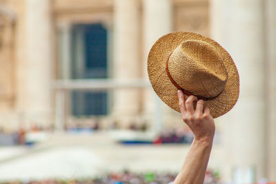 White man arm and hand hanging a hat