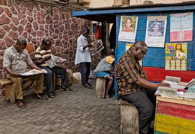 Group of people sitting against the wall