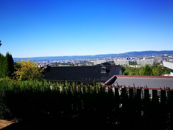 View of cityscape against clear blue sky