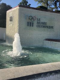 Water fountain in swimming pool against building