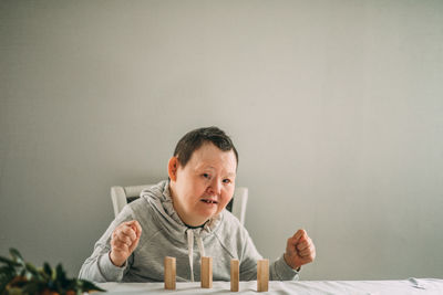 An elderly woman with down syndrome builds towers of their wooden toy blocks