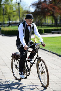 Man riding bicycle on footpath