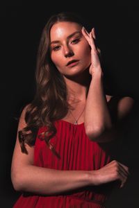 Beautiful young woman against black background