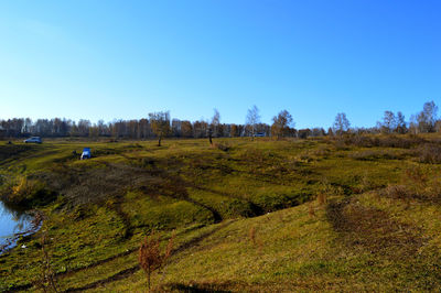 Scenic view of green landscape against clear blue sky