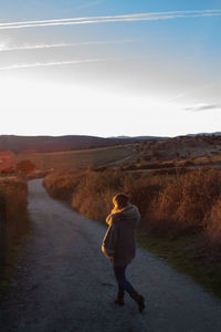 Rear view of man walking on road