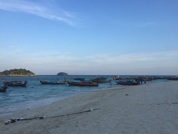 Boats moored on beach against sky