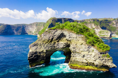 Scenic view of rock formation in sea against sky