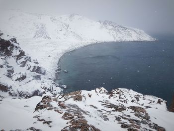 Scenic view of snowcapped mountains by sea