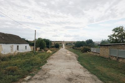 Road amidst buildings against sky