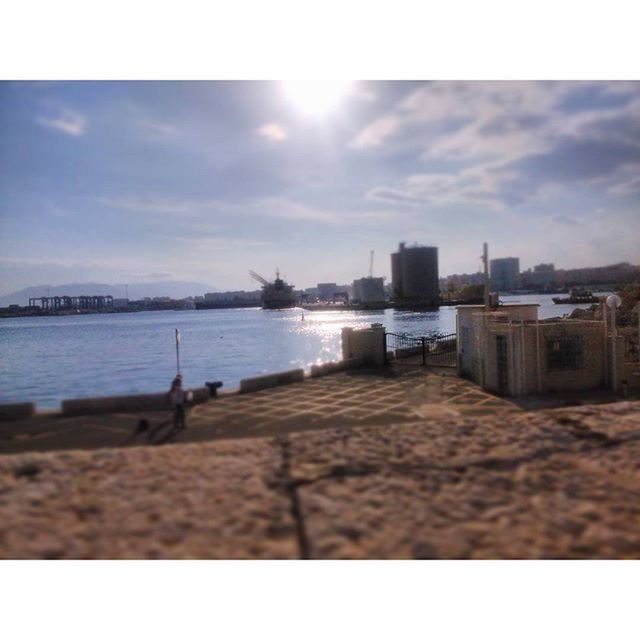 sky, building exterior, architecture, water, built structure, sea, transfer print, city, cloud - sky, cloud, sunlight, auto post production filter, beach, day, outdoors, railing, river, nature, cloudy, cityscape