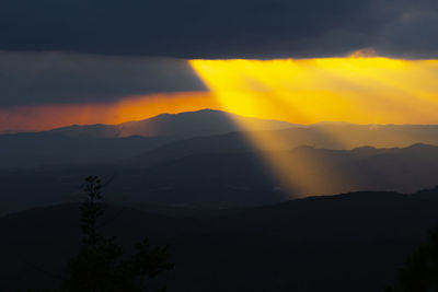 Scenic view of silhouette mountains against sky during sunset