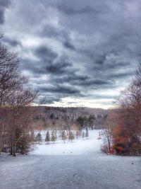 Scenic view of snow covered landscape against cloudy sky