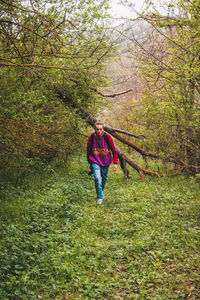 Full length of woman standing on land in forest