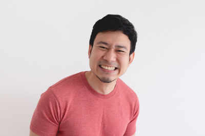 Portrait of smiling young man against white background