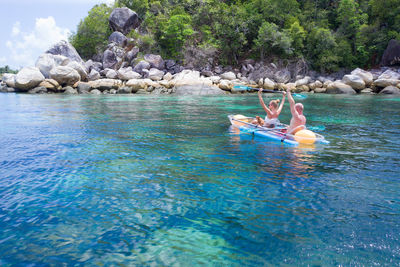 People on rock in sea