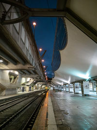 Illuminated railroad station platform at night