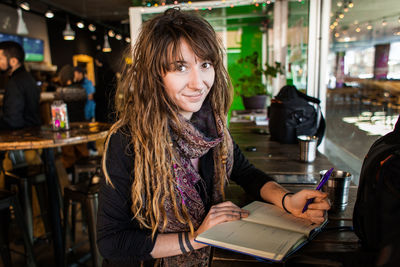 Portrait of smiling woman sitting at restaurant