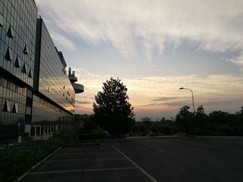 Road by city against sky during sunset