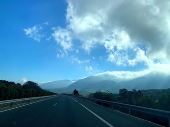 Empty road against cloudy sky