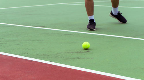 Low section of man playing tennis on court. tennis player shoe