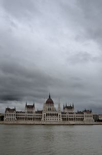 Built structure in water against cloudy sky