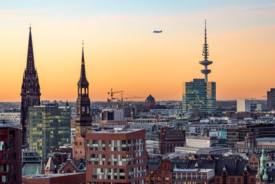 Buildings in city against sky during sunset