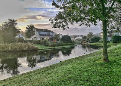 Houses by lake against sky