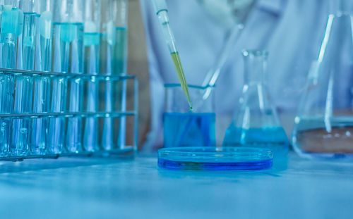 Midsection of scientist examining chemical in laboratory