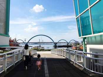 People on bridge against sky